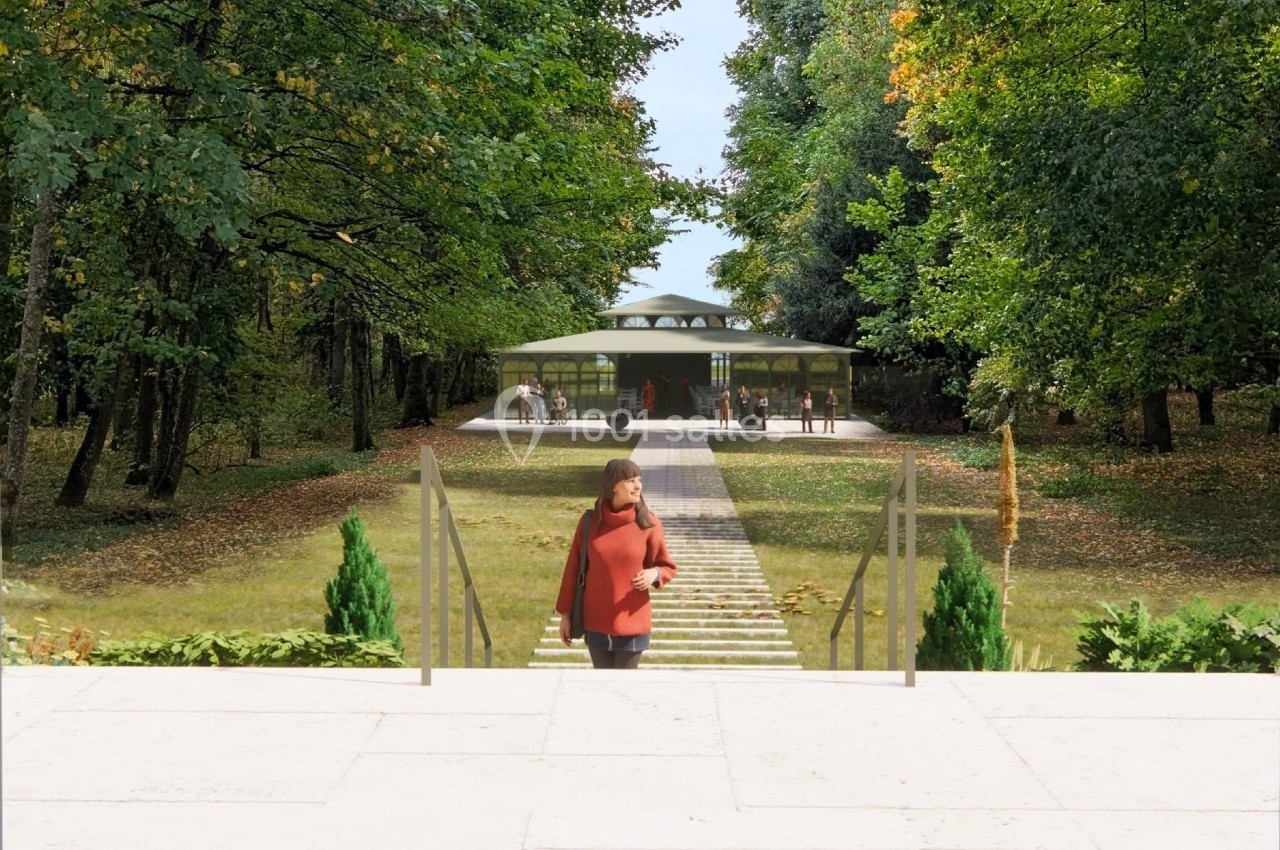 Une femme marche sur un escalier en pierre menant à un bâtiment moderne entouré d'arbres dans un parc.