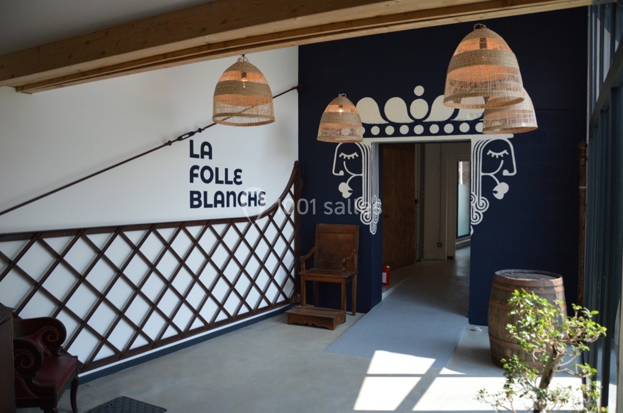 Entrée d'un espace intérieur avec des lampes suspendues, une décoration murale et un tonneau en bois.