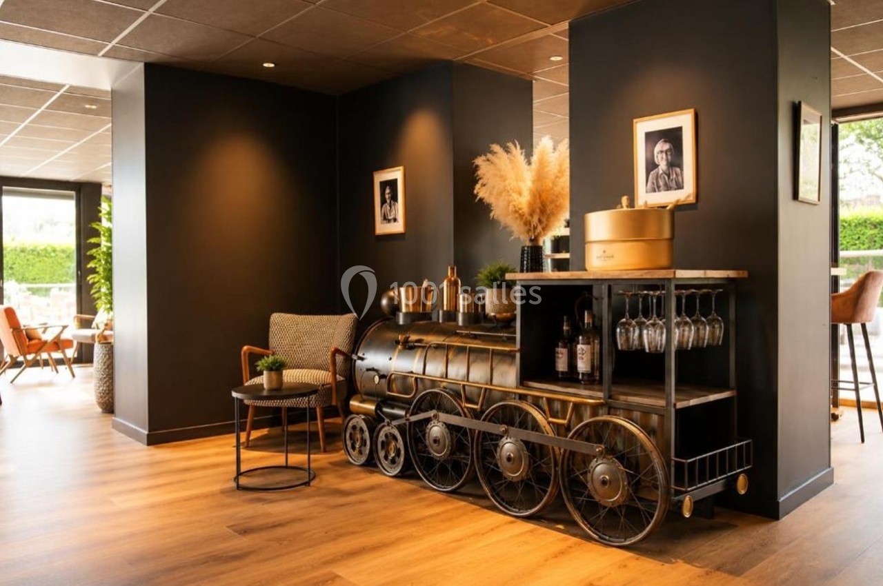 Meuble en forme de locomotive avec étagères, verres suspendus et décorations, dans un intérieur moderne et chaleureux.