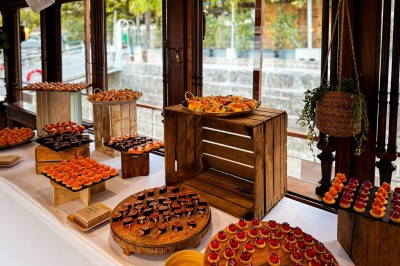 Miniature Traiteur Paris 20 (Paris) - Atelier des Sens #46 Table garnie de plats variés, incluant charcuterie et fromages, installée en extérieur près d'un plan d'eau.