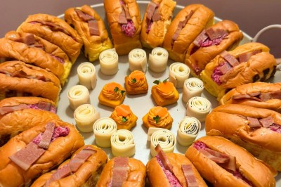 Miniature Traiteur Paris 20 (Paris) - Atelier des Sens #50 Table garnie de plats variés, incluant charcuterie et fromages, installée en extérieur près d'un plan d'eau.