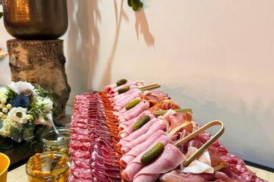 Miniature Traiteur Paris 20 (Paris) - Atelier des Sens #61 Table garnie de plats variés, incluant charcuterie et fromages, installée en extérieur près d'un plan d'eau.