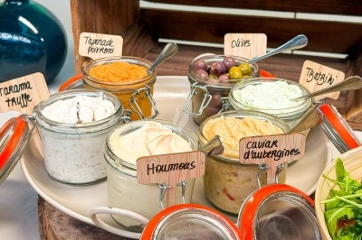 Miniature Traiteur Paris 20 (Paris) - Atelier des Sens #31 Plateau de charcuterie, fromages, pains et condiments disposés sur une table pour un repas convivial.