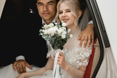 Miniature Germain Photo Reporter #5 Une femme en robe de mariée tient un bouquet de tournesols près d'une voiture ancienne rouge, de nuit.