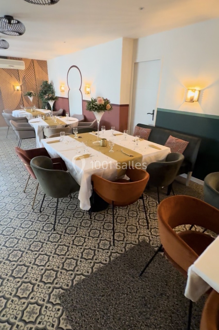 Salle de restaurant élégante avec tables dressées, chaises colorées et décoration murale moderne.