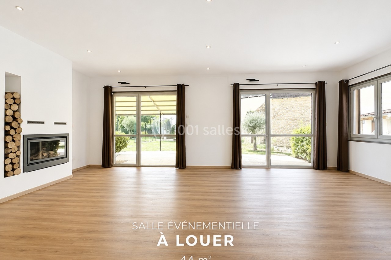 Salle lumineuse avec parquet, grandes baies vitrées, cheminée moderne et vue sur un jardin.