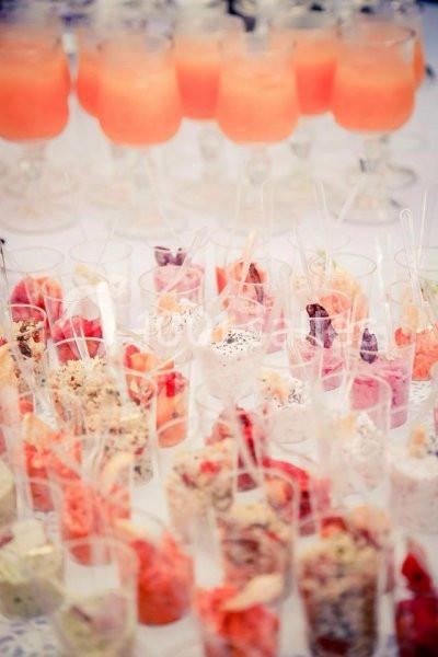 Verrines colorées et cocktails fruités disposés sur une table lors d'un événement ou d'une réception.