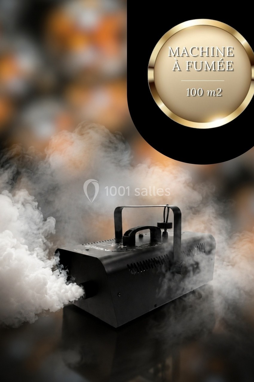 Machine à fumée noire en fonctionnement, diffusant de la fumée blanche dans un environnement sombre.