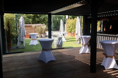 Miniature Location salle Toulouse (Haute-Garonne) - La Cantine d'Horace #4 Terrasse extérieure avec tables et chaises sous des parasols, entourée de verdure et située près d'un bâtiment industriel.