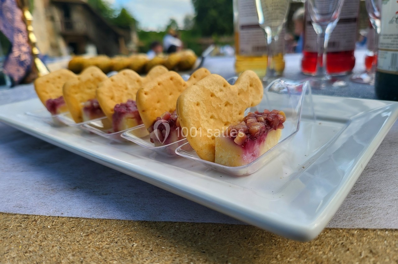 Assortiment de biscuits en forme de cœur garnis de fromage et confiture, présentés sur un plateau blanc.