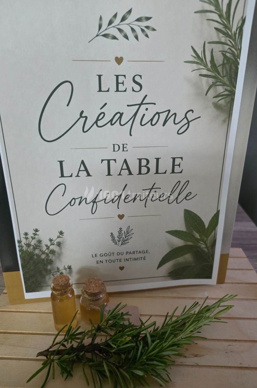 Affiche avec des herbes aromatiques, deux flacons en verre et le texte ’Les créations de la table confidentielle’.