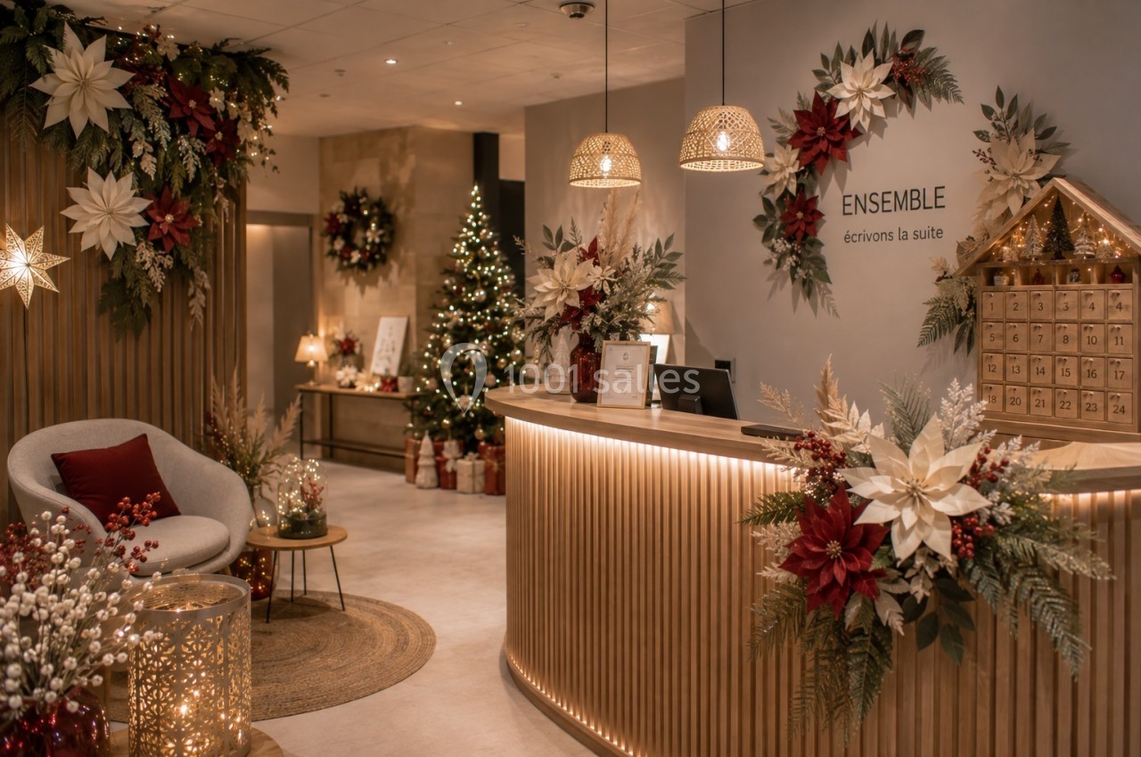 Décoration de Noël chaleureuse dans un espace d'accueil avec sapin, guirlandes lumineuses et couronnes festives.