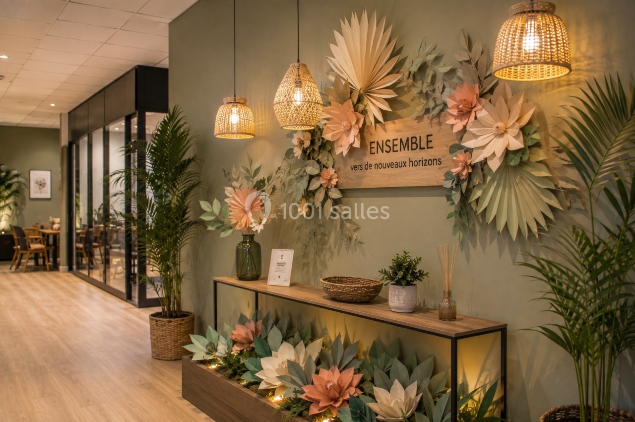 Décoration murale avec des fleurs en papier pastel, éclairée par des suspensions en rotin dans un espace intérieur…