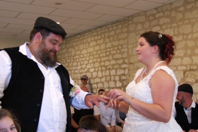 Miniature Rayon des Lys #7 Un couple échange des alliances lors d'une cérémonie de mariage dans une salle aux murs en pierre.