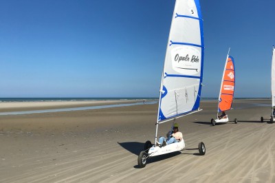 Groupe de personnes s'étirant sur une plage de sable face à la mer sous un ciel nuageux.