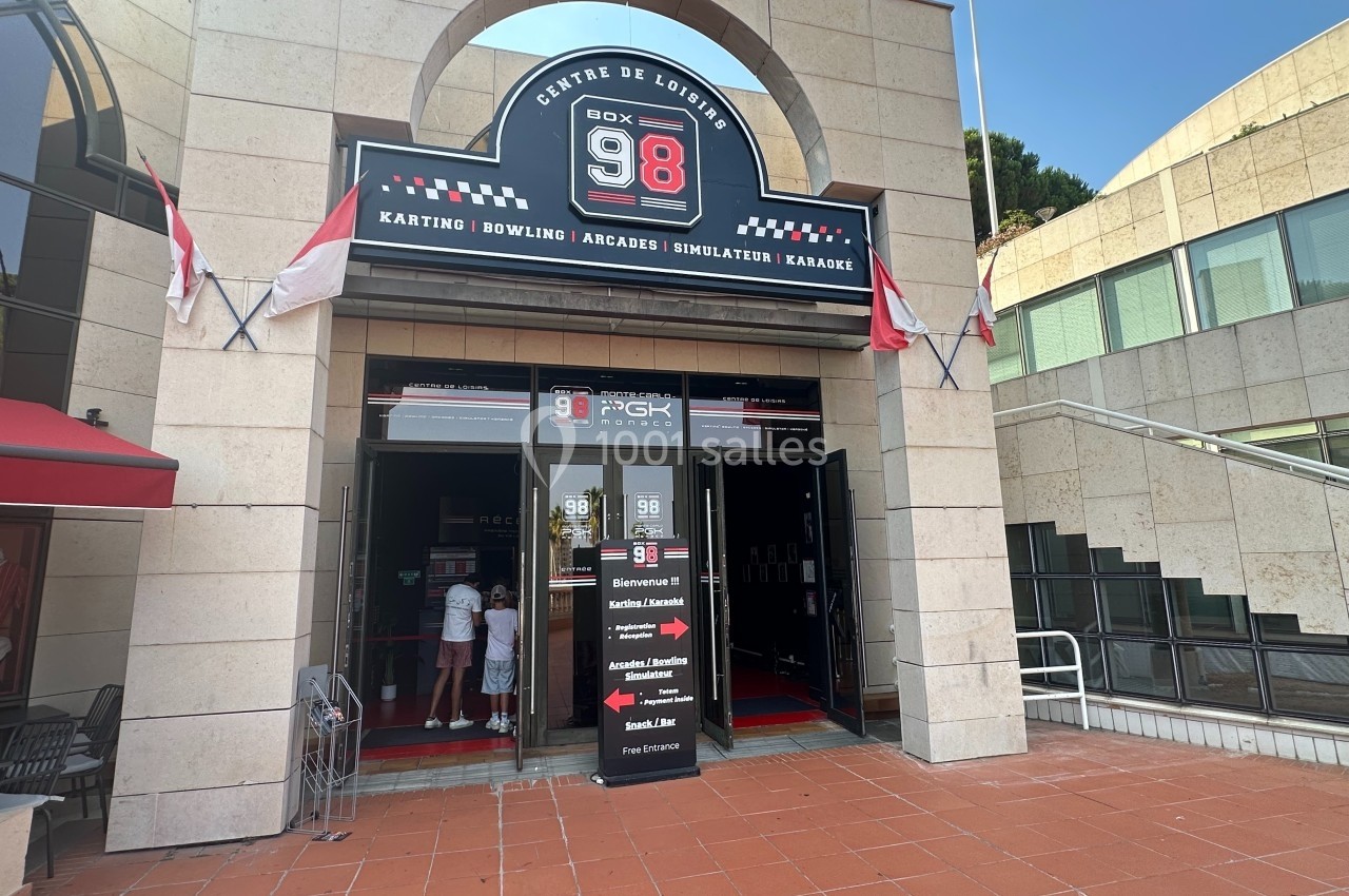 Entrée d'un centre de loisirs avec enseigne indiquant karting, bowling, arcades, simulateurs et espace détente.