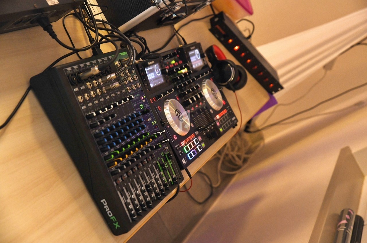 Table de mixage professionnelle avec platines, curseurs, boutons et casque audio posés sur un bureau.
