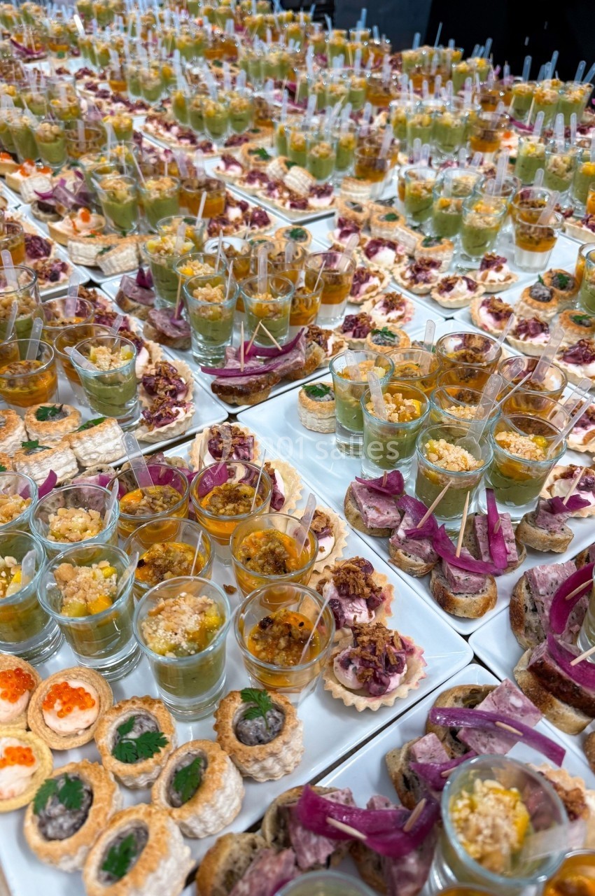 Plateaux de verrines et amuse-bouches variés disposés pour un buffet ou un événement.