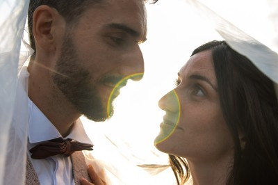 Femme de profil se faisant maquiller les lèvres avec un pinceau dans un cadre lumineux.