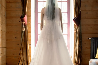 Femme de profil se faisant maquiller les lèvres avec un pinceau dans un cadre lumineux.