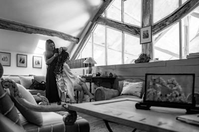 Femme de profil se faisant maquiller les lèvres avec un pinceau dans un cadre lumineux.