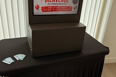 Miniature GFE LOC Photobooth #7 Des jeunes utilisent une borne photo lors d'une fête, avec des ballons dorés formant le chiffre 18 en arrière-plan.