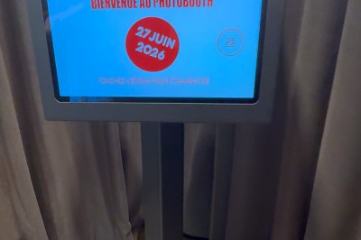 Miniature GFE LOC Photobooth #9 Des jeunes utilisent une borne photo lors d'une fête, avec des ballons dorés formant le chiffre 18 en arrière-plan.