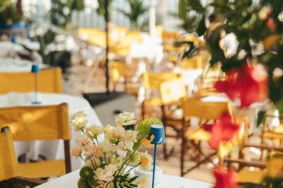 Plateau de blinis garnis de crème, saumon fumé et fleurs comestibles, présenté sur une terrasse ensoleillée.