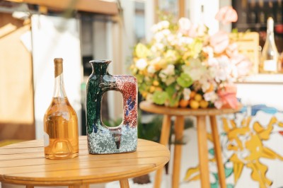 Plateau de blinis garnis de crème, saumon fumé et fleurs comestibles, présenté sur une terrasse ensoleillée.