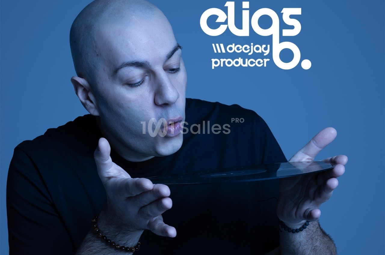 Homme chauve soufflant sur un disque vinyle, fond bleu avec texte ’deejay producer’.