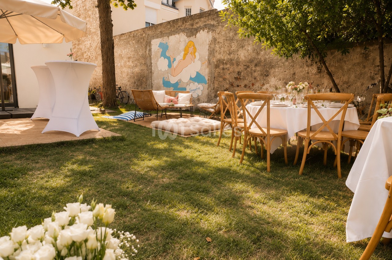 Cour intérieure aménagée pour événement avec tables dressées, chaises en bois et mur orné de fresque murale.