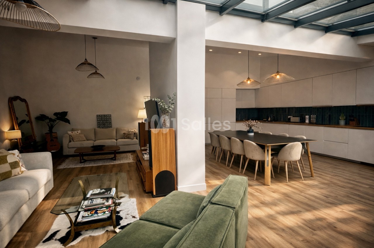 Espace ouvert combinant salon avec canapés et coin repas avec table - cuisinette intégrée, plafond vitré.