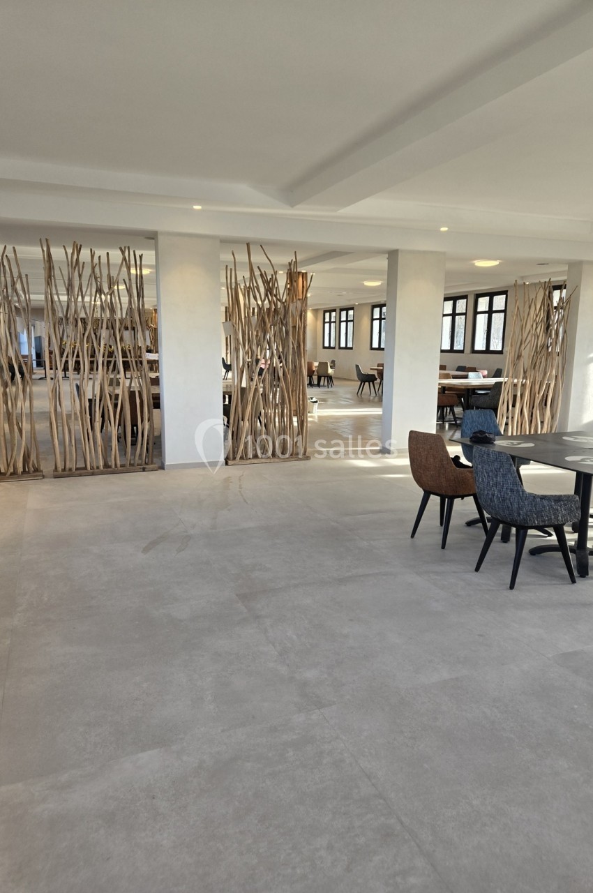 Espace intérieur lumineux avec sol en carrelage clair, séparations en bois naturel et mobilier moderne.