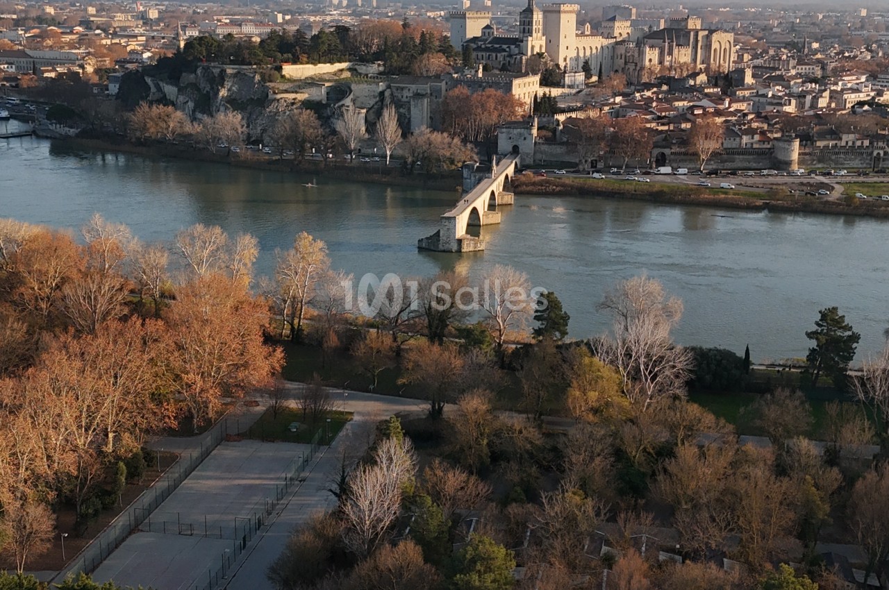 Vue aérienne d'Avignon avec le Rhône, le pont Saint-Bénézet, le palais des Papes et la ville en arrière-plan.