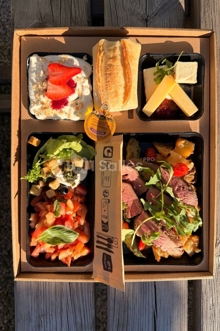 Boîte en carton ouverte à compartiments contenant une salade de tomates et basilic, une assiette de tranches de viande rosée avec roquette, une coupelle de fromages, une coupelle de fromage blanc aux fraises et un petit pain. Let me check the length