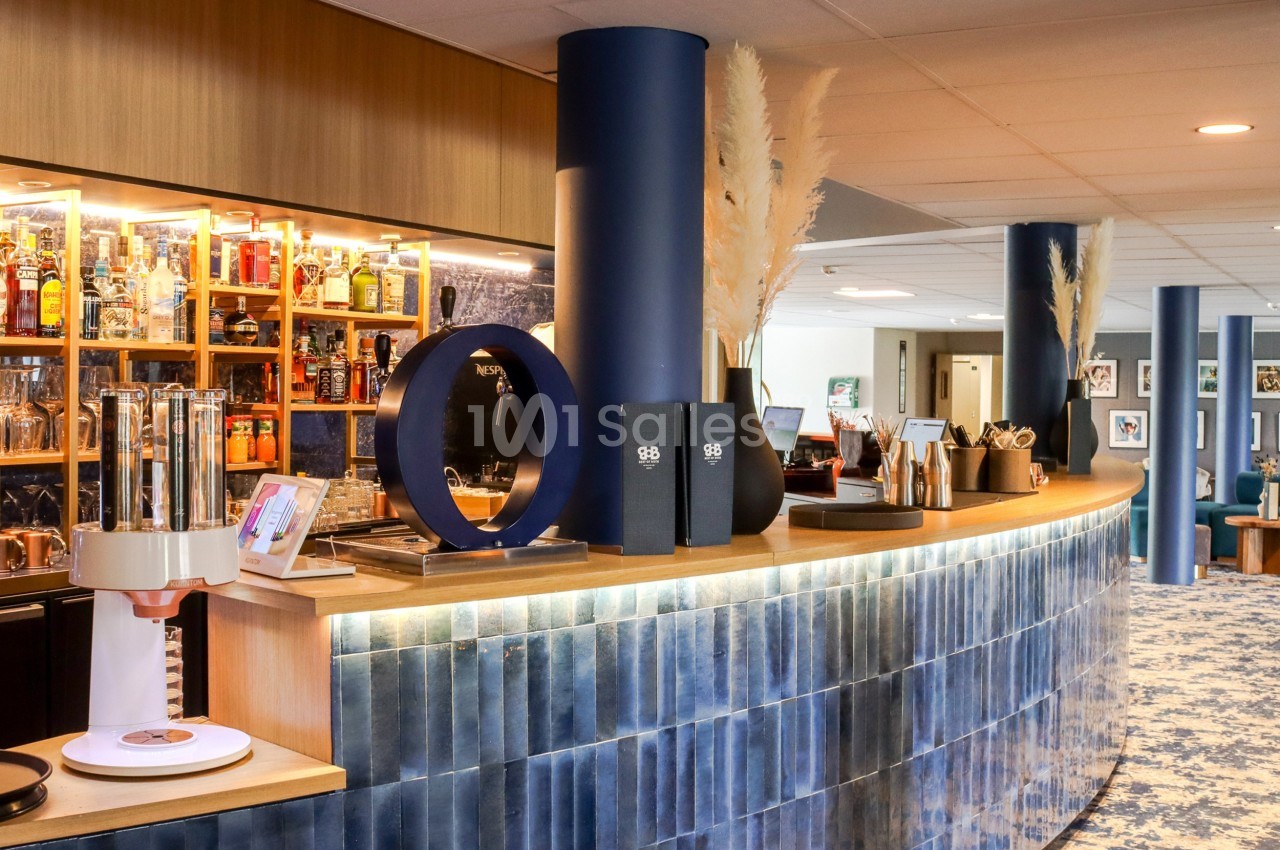 Comptoir de bar moderne avec étagères remplies de bouteilles, décoration contemporaine et lumière chaleureuse.