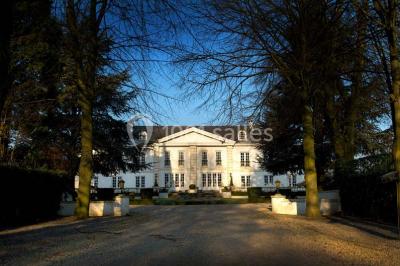 Fleurs blanches posées sur une table en bois, avec un fond flou de lumières et de décorations.