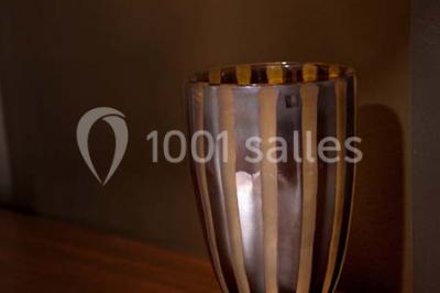 Fleurs blanches posées sur une table en bois, avec un fond flou de lumières et de décorations.