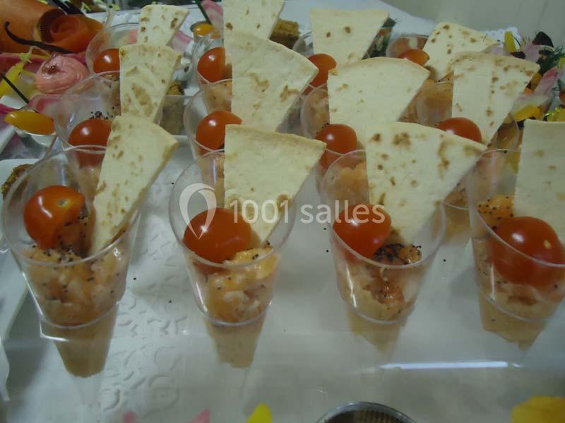 Verrines apéritives garnies de tartare de saumon, tomates cerises et triangles de pain pita.
