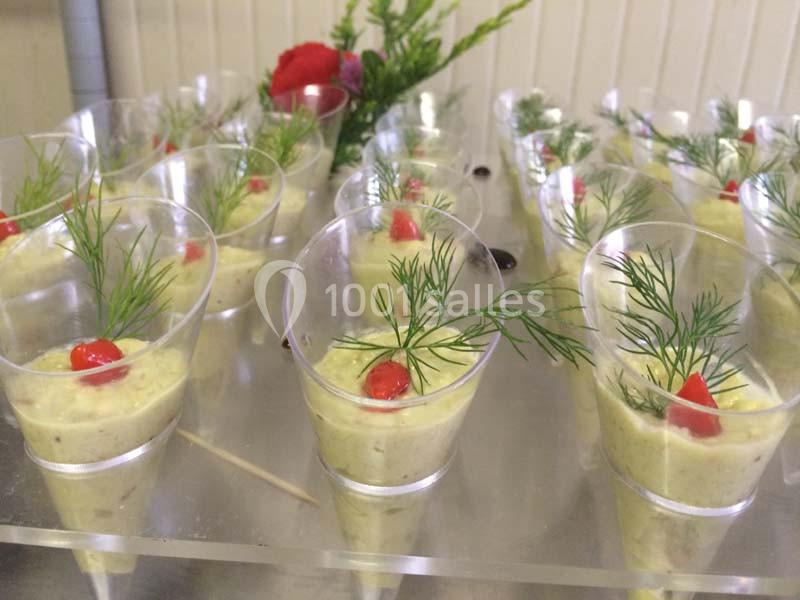 Verrines de mousse verte garnies d'aneth et de morceaux de poivron rouge, disposées sur une table.
