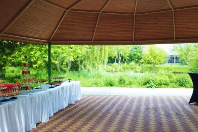 Bâtiment blanc moderne à deux étages avec colonnes, grandes fenêtres et espace paysager à l'avant.