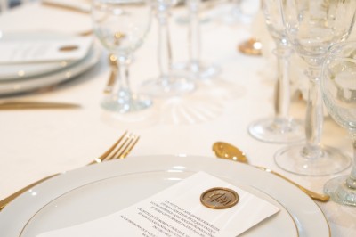 Bâtiment blanc moderne à deux étages avec colonnes, grandes fenêtres et espace paysager à l'avant.