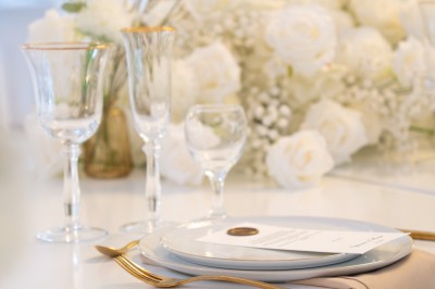 Bâtiment blanc moderne à deux étages avec colonnes, grandes fenêtres et espace paysager à l'avant.