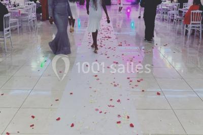 Buffet de desserts avec macarons colorés, verrines et pâtisseries disposés sur des présentoirs décoratifs dans une salle…