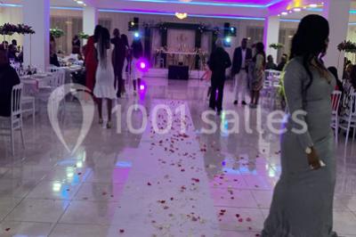 Buffet de desserts avec macarons colorés, verrines et pâtisseries disposés sur des présentoirs décoratifs dans une salle…