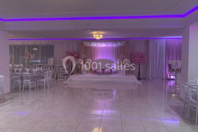 Buffet de desserts avec macarons colorés, verrines et pâtisseries disposés sur des présentoirs décoratifs dans une salle…