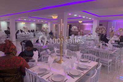 Buffet de desserts avec macarons colorés, verrines et pâtisseries disposés sur des présentoirs décoratifs dans une salle…