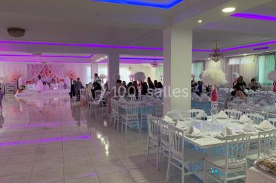 Buffet de desserts avec macarons colorés, verrines et pâtisseries disposés sur des présentoirs décoratifs dans une salle…