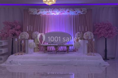 Buffet de desserts avec macarons colorés, verrines et pâtisseries disposés sur des présentoirs décoratifs dans une salle…