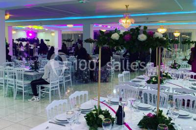 Buffet de desserts avec macarons colorés, verrines et pâtisseries disposés sur des présentoirs décoratifs dans une salle…